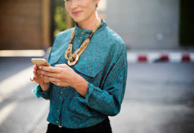 woman smiling checking her phone