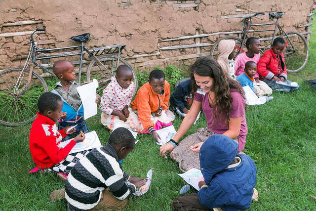 young woman coloring with children on a globalx journey