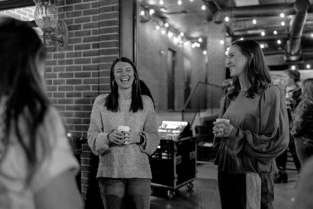 young adult women gathering outside drinking coffee